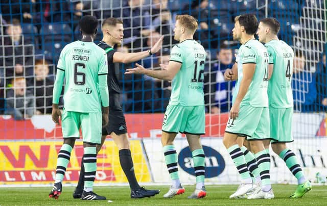 Referee David Dickinson is surrounded by Hibs players after awarding Kilmarnock a penalty.