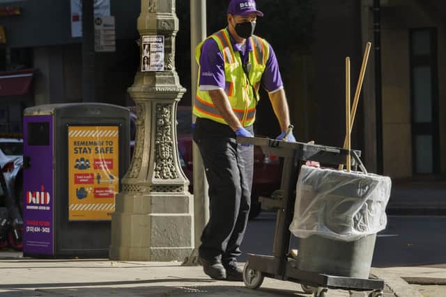 A maintenance contractor in downtown Los Angeles wears gloves and a face mask (Picture: Damian Dovarganes/AP)