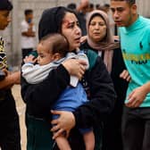 An injured woman carries a baby in the aftermath of Israeli bombing in Rafah in the southern Gaza Strip. Picture: Mohammed Abed/AFP via Getty Images