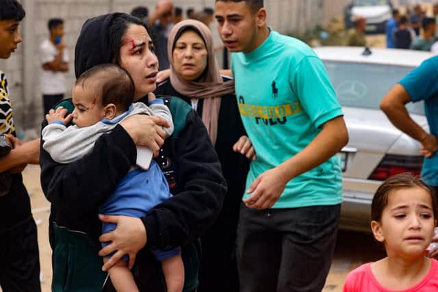 An injured woman carries a baby in the aftermath of Israeli bombing in Rafah in the southern Gaza Strip. Picture: Mohammed Abed/AFP via Getty Images