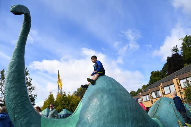 Children play on a Loch Ness monster sculpture at Nessieland in Drumnadrochit in the Highlandsn(Picture: Andy Buchanan/AFP via Getty Images)
