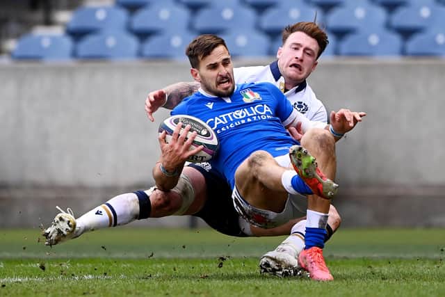 Stand off for the day Stuart Hogg is in the thick of the midfield action with this tackle on Italy's Mattia Bellini