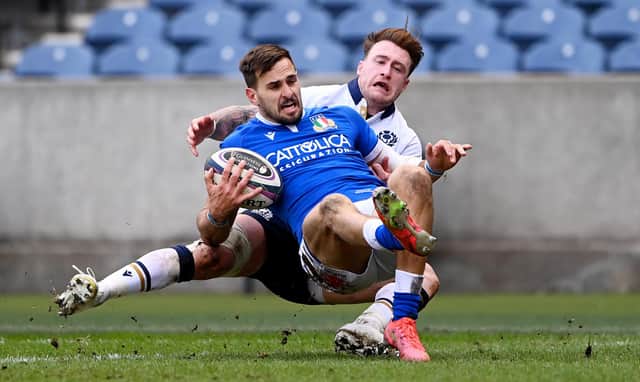 Stand off for the day Stuart Hogg is in the thick of the midfield action with this tackle on Italy's Mattia Bellini