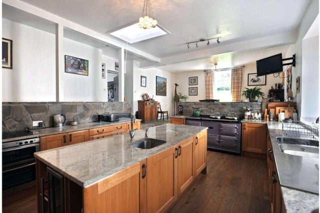 The kitchen itself was only recently installed and includes an Aga, various integrated appliances, and a central island with a granite worktop.
