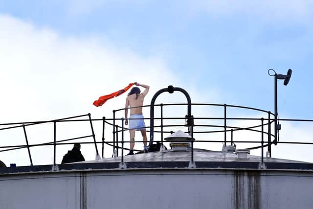 A protester takes to the roof of a building at the Nustar Oil Depot in Clydebank
Pic: John Devlin