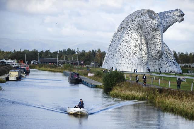 Scottish Canals activities assistant Rebecca Brown aboard one of its electric boats on the Forth & Clyde Canal at the Kelpies. (Photo by Lisa Ferguson/The Scotsman)