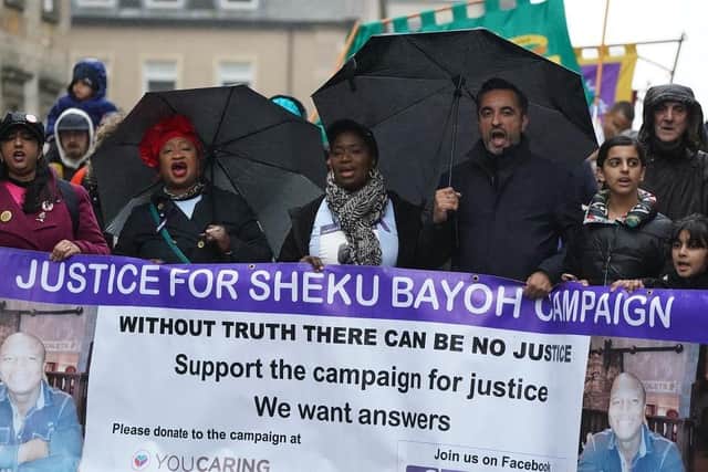 The sister of Sheku Bayoh, Kadi Johnston (centre) and Human rights lawyer Aamer Anwar (right) during a anti-racism and anti-fascist march in Glasgow,