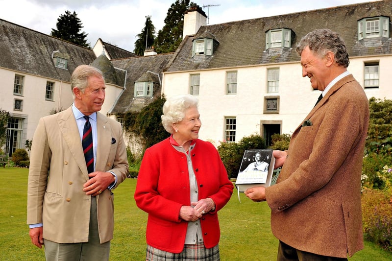 Queen Elizabeth II and Prince Charles are presented with one of the first copies of 'Queen Elizabeth the Queen Mother, The Official Biography' by author William Shawcross in the garden at Birkhall the Scottish home of the Prince and Duchess of Cornwall on September 2, 2009.