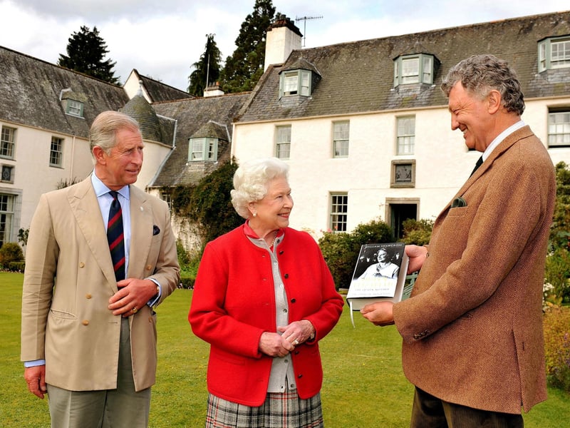 Queen Elizabeth II and Prince Charles are presented with one of the first copies of 'Queen Elizabeth the Queen Mother, The Official Biography' by author William Shawcross in the garden at Birkhall the Scottish home of the Prince and Duchess of Cornwall on September 2, 2009.