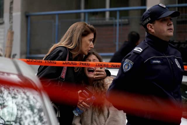 A parent escorts her child following a shooting at a school in the capital Belgrade. Picture: Oliver Bunic/AFP via Getty Images