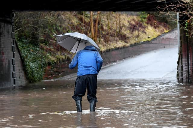 A man caught in a flooded area after a spell of heavy downpours picture: John Devlin/JPI Media