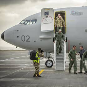 Crew disembark and greet their colleagues with an "elbow bump" at the bottom of the steps of the first of the Poseidon MRA1 planes, intended for submarine-hunting and the tracking of maritime targets, after arriving at RAF Lossiemouth, Moray.