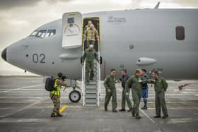 Crew disembark and greet their colleagues with an "elbow bump" at the bottom of the steps of the first of the Poseidon MRA1 planes, intended for submarine-hunting and the tracking of maritime targets, after arriving at RAF Lossiemouth, Moray.