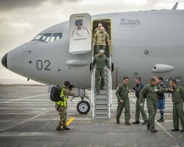 Crew disembark and greet their colleagues with an "elbow bump" at the bottom of the steps of the first of the Poseidon MRA1 planes, intended for submarine-hunting and the tracking of maritime targets, after arriving at RAF Lossiemouth, Moray.