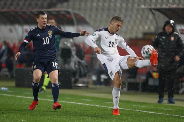Darko Lazovic of Serbia clears the ball as Callum McGregor of Scotland looks on.