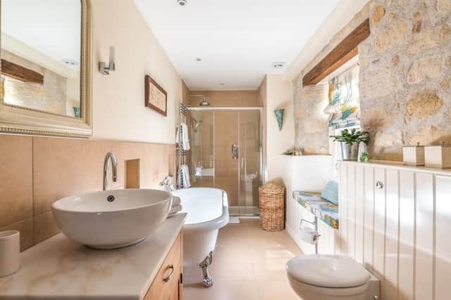 One of the ensuite bathrooms with roll top bath and walk-in rain shower.