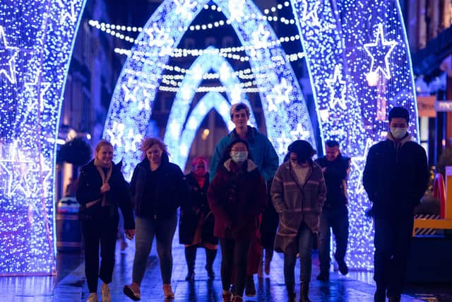 Shoppers walk through Christmas lights on South Molton Street, in central London.