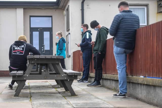 Young people are seen queuing outside a mobile vaccine unit on May 13, 2021 in Lossiemouth, Scotland. (Photo by Peter Summers/Getty Images)