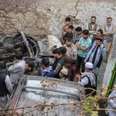 Afghan residents and family members of the victims gather next to a damaged vehicle inside a house, after a US drone airstrike in Kabul. Picture: Wakil Kohsar/AFP via Getty Images