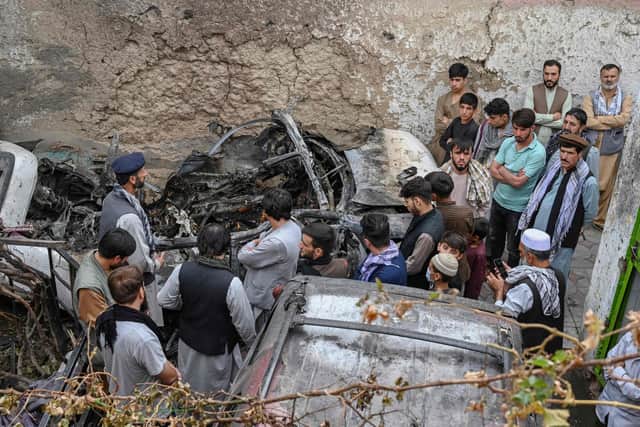 Afghan residents and family members of the victims gather next to a damaged vehicle inside a house, after a US drone airstrike in Kabul. Picture: Wakil Kohsar/AFP via Getty Images
