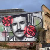 The mural was made by Rogue One, a local street artist, in collaboration with Art Pistol Projects. It depicts Mackintosh in a monochromatic style looking through a stained glass window with the architect’s iconic Glasgow Rose motif. It overlooks Glasgow’s Clutha Bar and marked the 150th anniversary of Mackintosh’s birth in 2018.