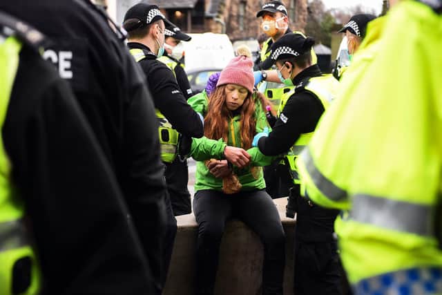 Police officers arrest a member of the public at an anti lockdown protest held by The Scotland Against Lockdown group outside the Scottish Parliament. Picture: Andy Buchanan/AFP via Getty Images
