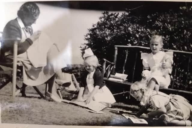 Astrid is pictured sitting on the bench, surrounded by friends, at the Foss Manse in 1947.  PIC: Contributed.