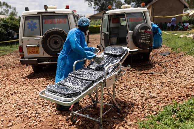 Red Cross workers clean ambulances prior to transporting Ebola victims to a hospital on October 13, 2022 in Mubende, Uganda