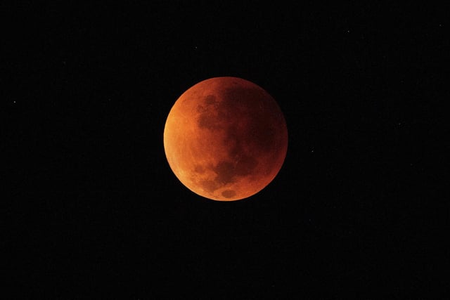 The blood moon is seen during a total lunar eclipse in Rio de Janeiro on May 16, 2022. (Photo by CARL DE SOUZA/AFP via Getty Images)