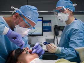 Dentist Fiez Mugha and Dental Nurse Johanna Bartha carry out a procedure on a patient. Photo by Leon Neal/Getty Images