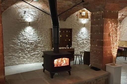 A cosy and rustic vaulted cellar has a roaring fire, cosy sofas, a table tennis table and other games.