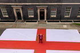 Prime Minister Boris Johnson poses for a photograph outside 10 Downing Street with a giant St George's flag ahead of the England Quarter Final game against Ukraine. Picture by Simon Dawson / No 10 Downing Street