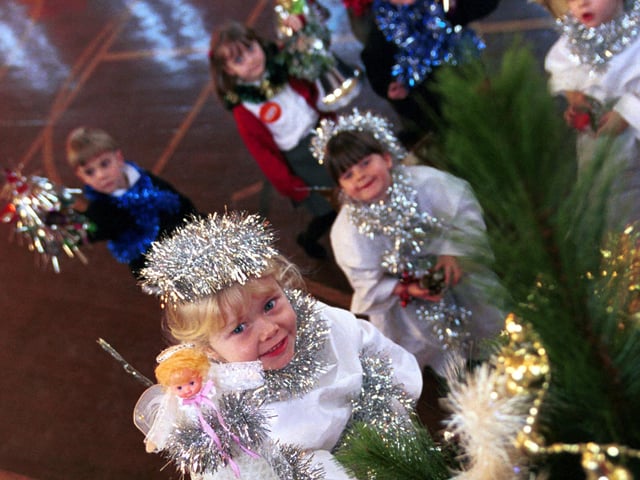 Hope McNicoll, primary one angel, places an angel on the top of the school Christmas tree as her Rosewell Primary School classmates look on. Picture: 15 December 2000