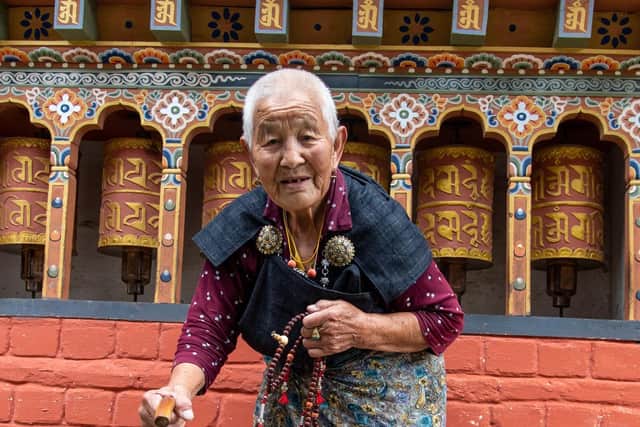 An elderly lady using prayer wheels at a temple along the Trans Bhutan trail. Pic: PA Photo/Sarah Marshall.