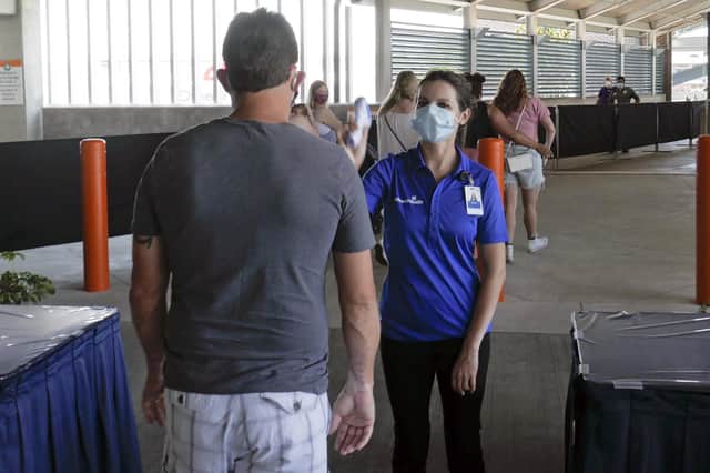 A guest goes through a temperature check designed to spot one symptom of Covid-19 coronavirus infection before entering the Disney Springs shopping, dining and entertainment complex in Lake Buena Vista, Flordia (Picture: John Raoux/AP)