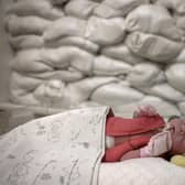 A child rests in a cot beside a window protected by sandbags in an intensive care unit for newborns at Okhmatdyt Hospital, Kyiv, yesterday (Picture: Jeff J Mitchell/Getty Images)