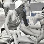 George Best pictured on a beach near Palma, Majorca with his landlady Mary Fullaway. Pic: Bob Aylott/Daily Mail/Shutterstock (1080079a)