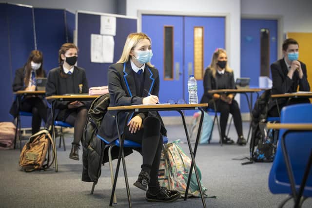 High school pupils have to wear masks in the classroom and maintain social distancing as they return to school part time.