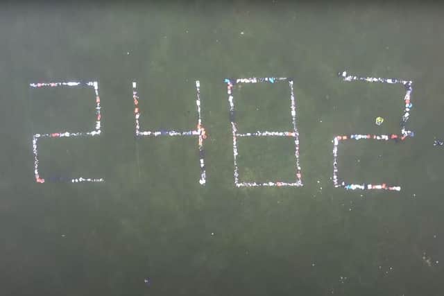 Locals write out the Scottish coronavirus death toll in The Meadows using rubbish bags. Credit: Dode Allen/ Youtube