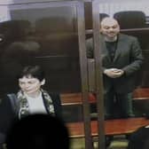 Vladimir Kara-Murza is seen on a TV screen as he stands in a glass cage at the Moscow City Court, where he was given a 25-year prison sentence (Picture: Alexander Zemlianichenko/AP)