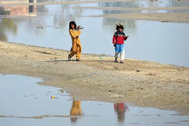 Internally displaced girls walk beside the flood waters near a makeshift camp in the flood-hit area of Dera Allah Yar in Jaffarabad district of Balochistan province, months after Pakistan was hit with devastating flooding. Picture: AFP via Getty Images