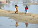 Internally displaced girls walk beside the flood waters near a makeshift camp in the flood-hit area of Dera Allah Yar in Jaffarabad district of Balochistan province, months after Pakistan was hit with devastating flooding. Picture: AFP via Getty Images