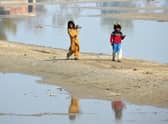 Internally displaced girls walk beside the flood waters near a makeshift camp in the flood-hit area of Dera Allah Yar in Jaffarabad district of Balochistan province, months after Pakistan was hit with devastating flooding. Picture: AFP via Getty Images
