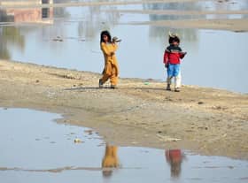 Internally displaced girls walk beside the flood waters near a makeshift camp in the flood-hit area of Dera Allah Yar in Jaffarabad district of Balochistan province, months after Pakistan was hit with devastating flooding. Picture: AFP via Getty Images