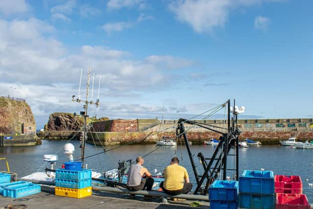 Fishermen sat on the harbour