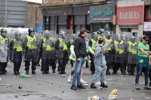 Police look on as Celtic fans celebrate in Glasgow after their side won the William Hill Premiership title after a 3-1 win at home to Hearts (Pictrure: Steve Welsh/PA Wire)