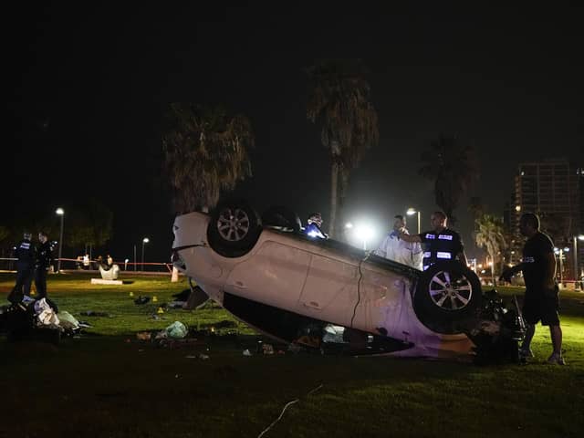 Israeli police stand around a car involved in an attack in Tel Aviv, Israel. (AP Photo/Ariel Schalit)