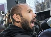 Police officers escort Andrew Tate, handcuffed to his brother Tristan, from the Directorate for Investigating Organized Crime and Terrorism. Picture: AP Photo/Andreea Alexandru