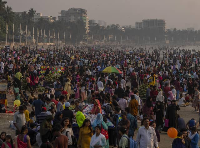 People crowd the Juhu beach on the Arabian Sea coast in Mumbai, India. The world's population is projected to hit an estimated 8 billion people on Tuesday, Nov. 15, according to a United Nations projection. (AP Photo/Rafiq Maqbool)