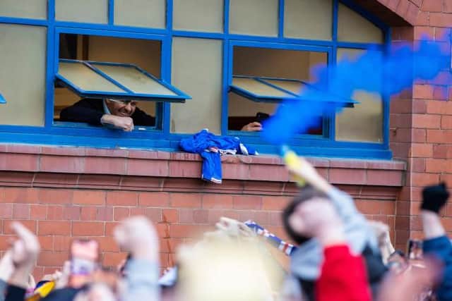 Rangers manager Steven Gerrard looks out of the dressing room window to greet supporters celebrating after the 3-0 win over St Mirren which effectively secured the Premiership title. (Photo by Craig Williamson / SNS Group)